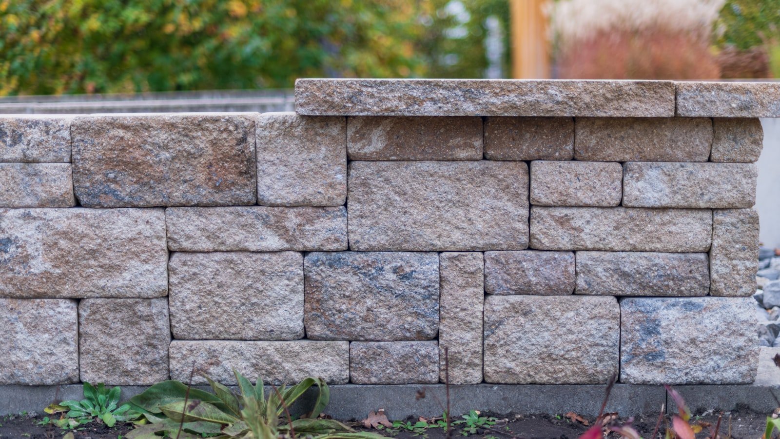 Natural armour stone retaining wall with landscaped greenery above